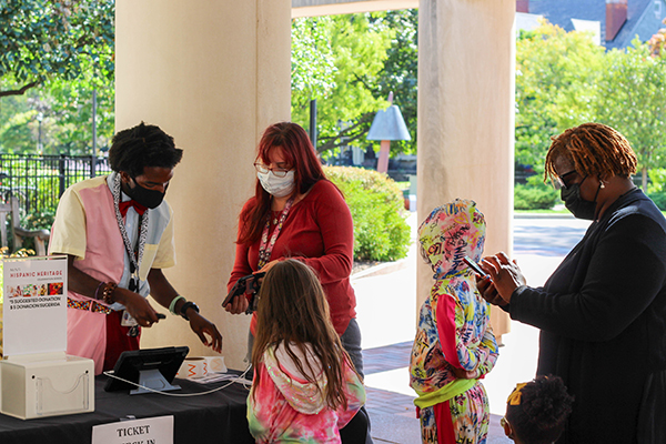 Two volunteers check a family in at an event