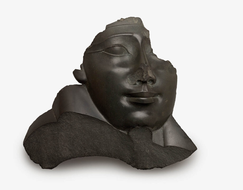 A broken sculpture of a face from a sarcophagus.