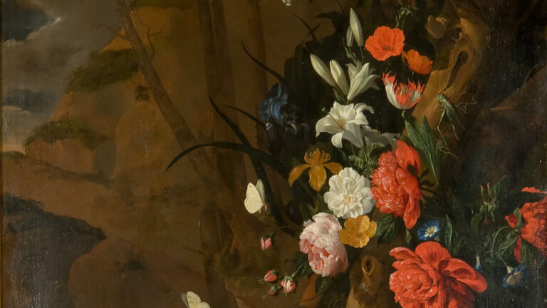 A cluster of bright flowers around a tree in a dark landscape.