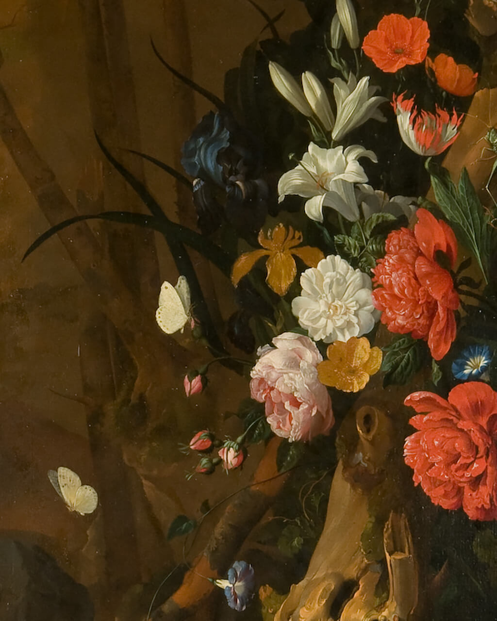 A cluster of bright flowers around a tree in a dark landscape.