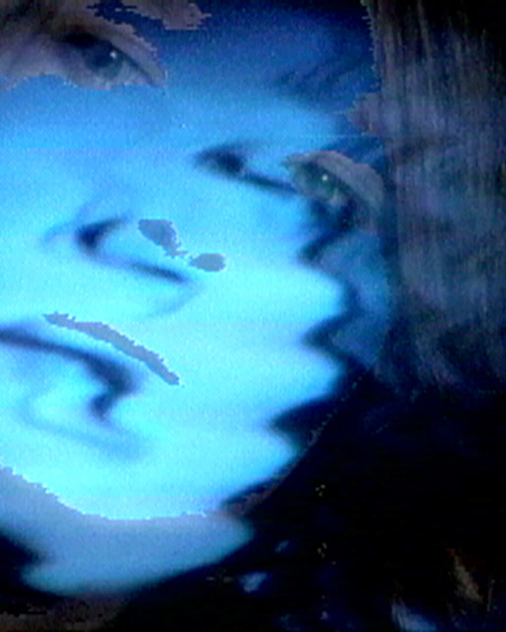 Still of a video, showing a wavery, fuzzy human face tinted shades of blue.