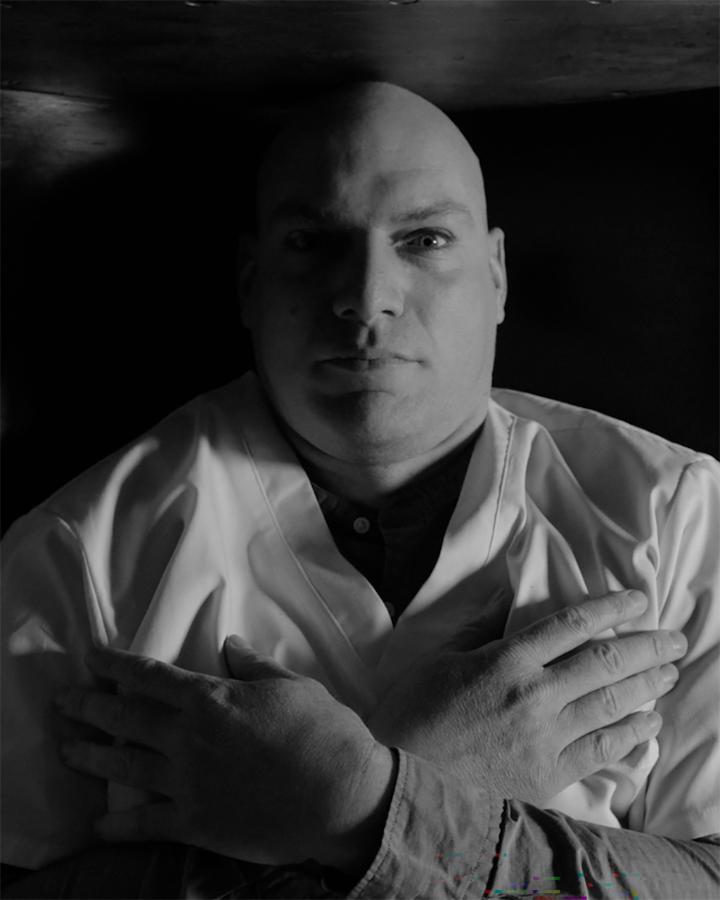 A man lies on his back, arms crossed across his chest.