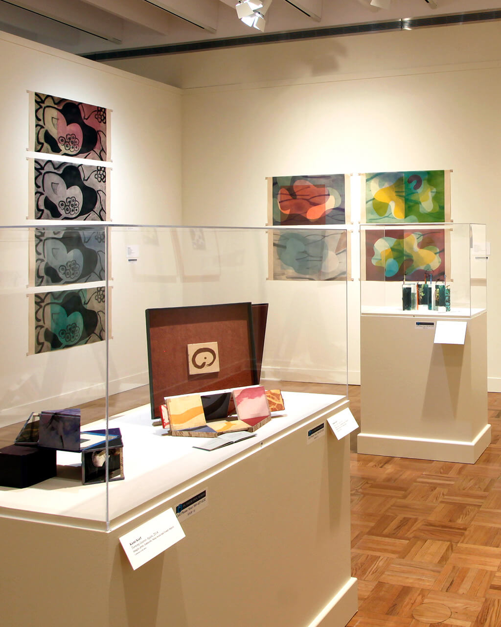 Works of art on the walls and on pedestals in a gallery.