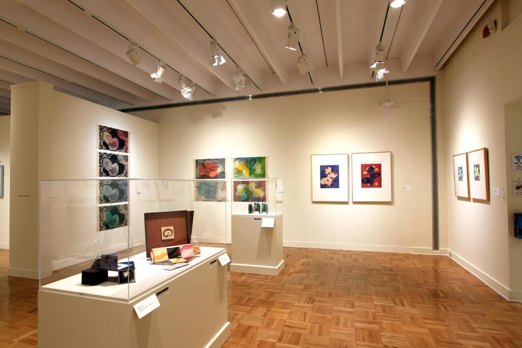 Works of art on the walls and on pedestals in a gallery.