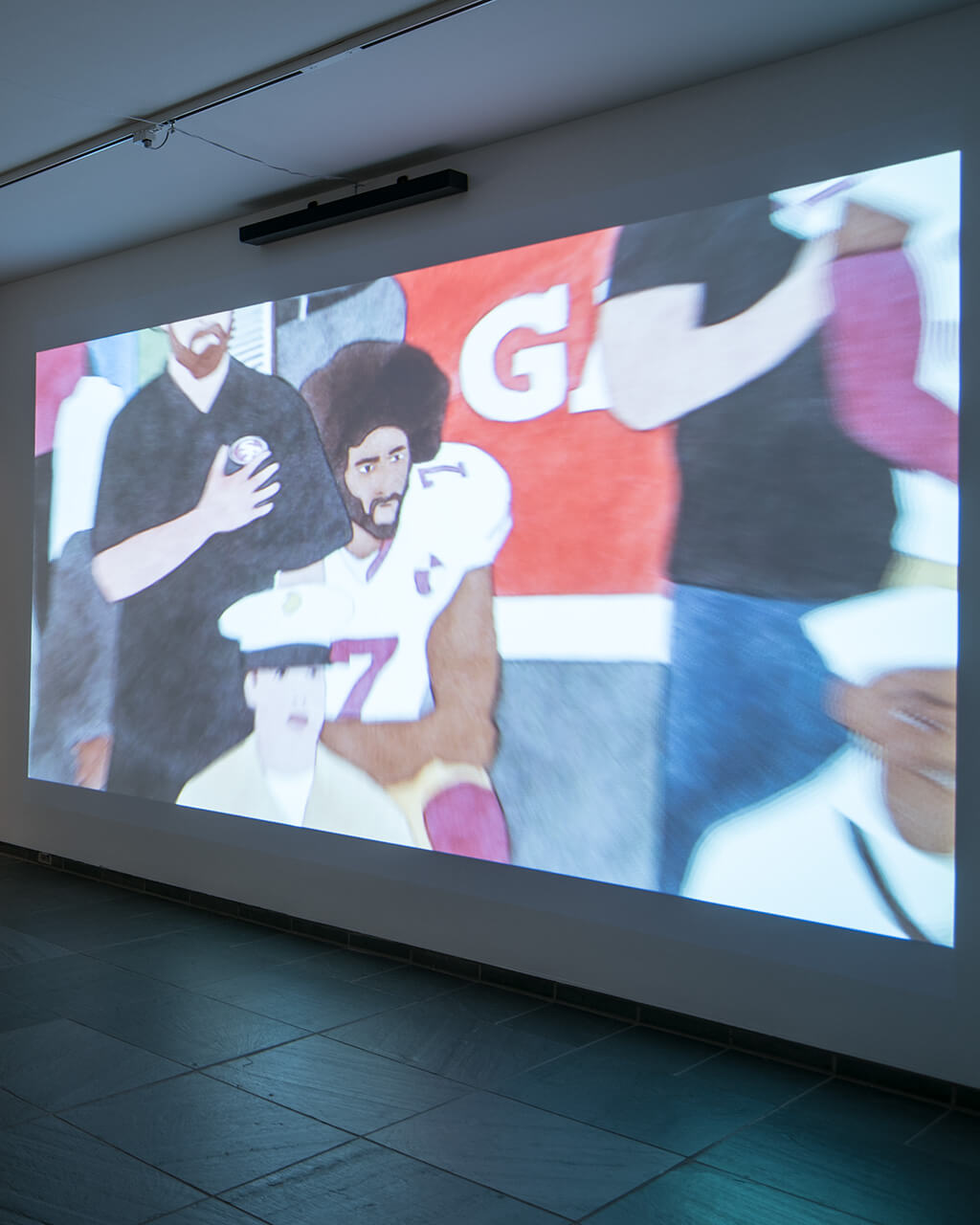 MAG's Forman Gallery with artwork projected on one wall and two lightboxes installed on another wall.