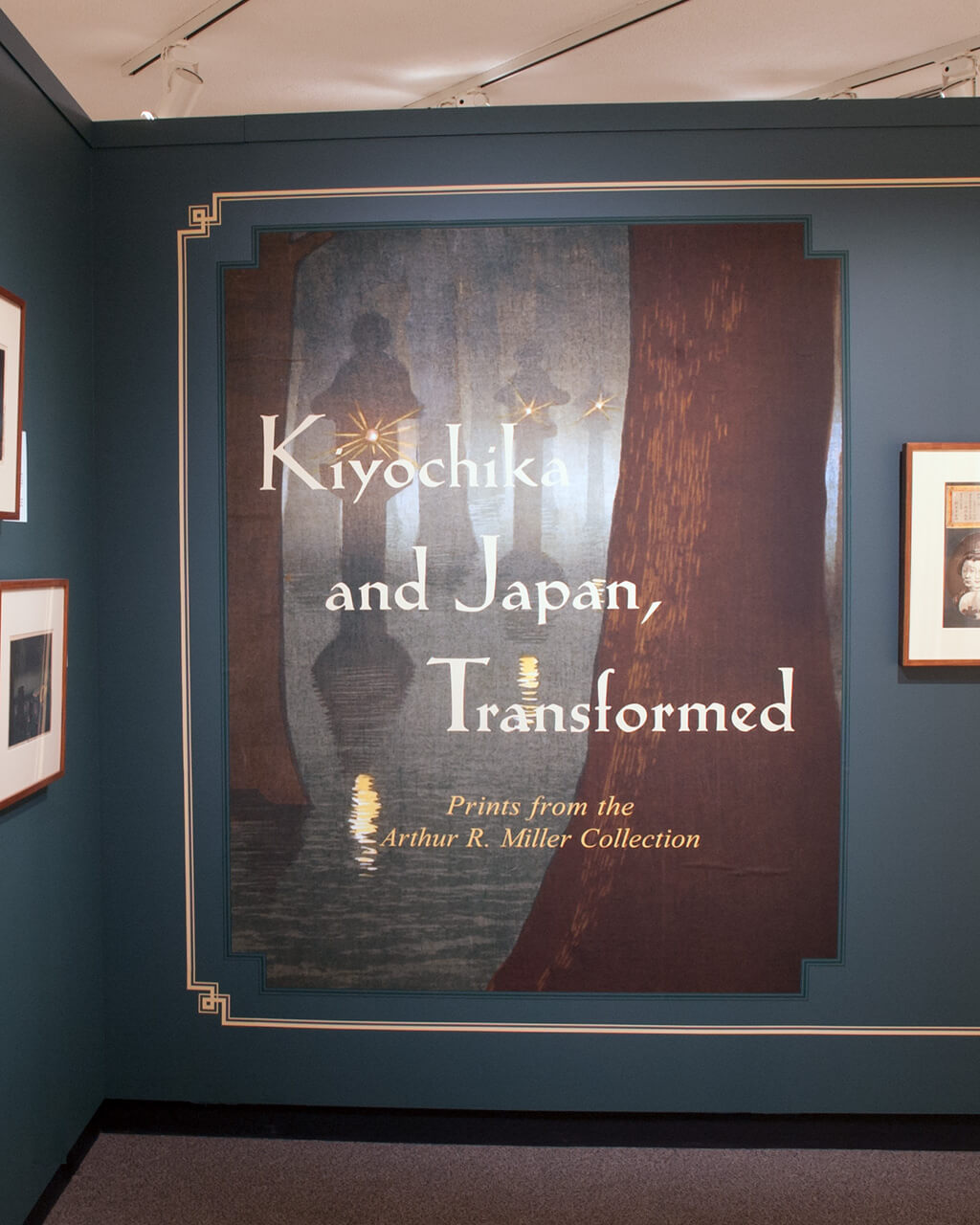 The title wall of the "Kiyochika & Japan, Transformed" exhibition, which has four prints and a text panel on it.