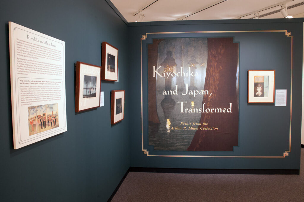 The title wall of the "Kiyochika & Japan, Transformed" exhibition, which has four prints and a text panel on it.