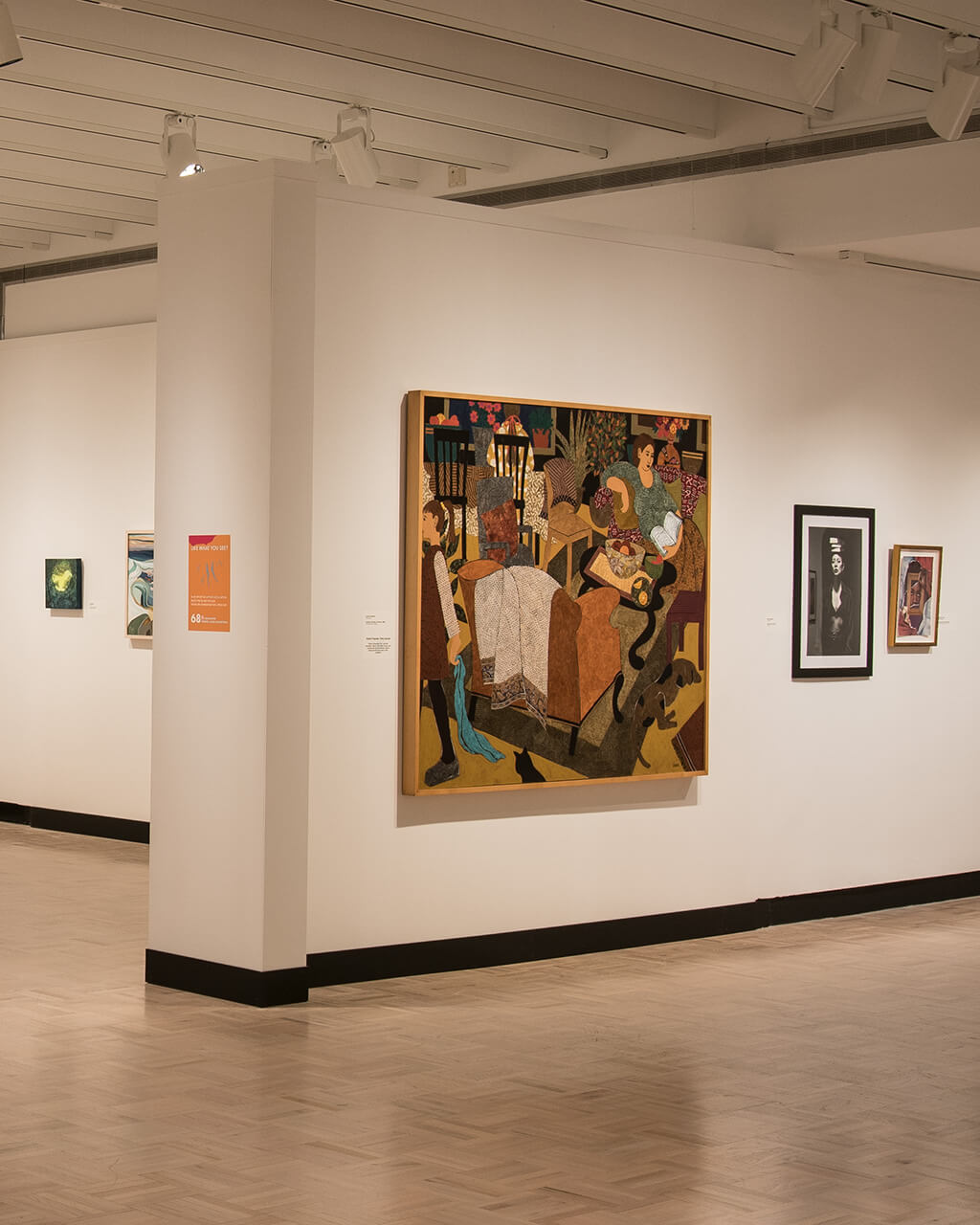 Many works of art hanging on white walls in MAG's Docent Gallery.