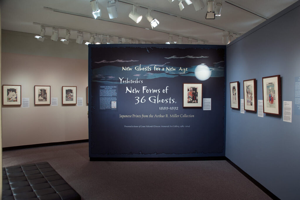 The title wall of the exhibition "New Ghosts for A New Age," with text and Japanese prints on a dark blue wall.