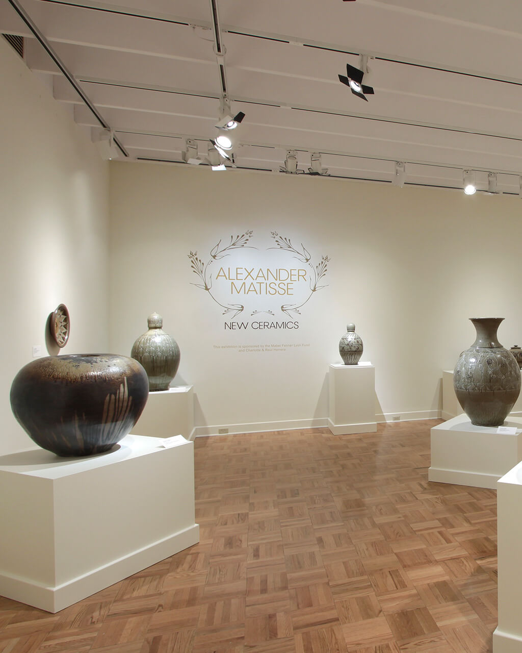 Ceramic vessels by Alexander Matisse on pedestals in a white-walled gallery.