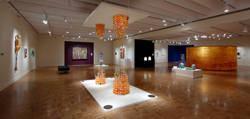 Artwork made out of nontraditional materials like prescription bottles on view in a large, open gallery.