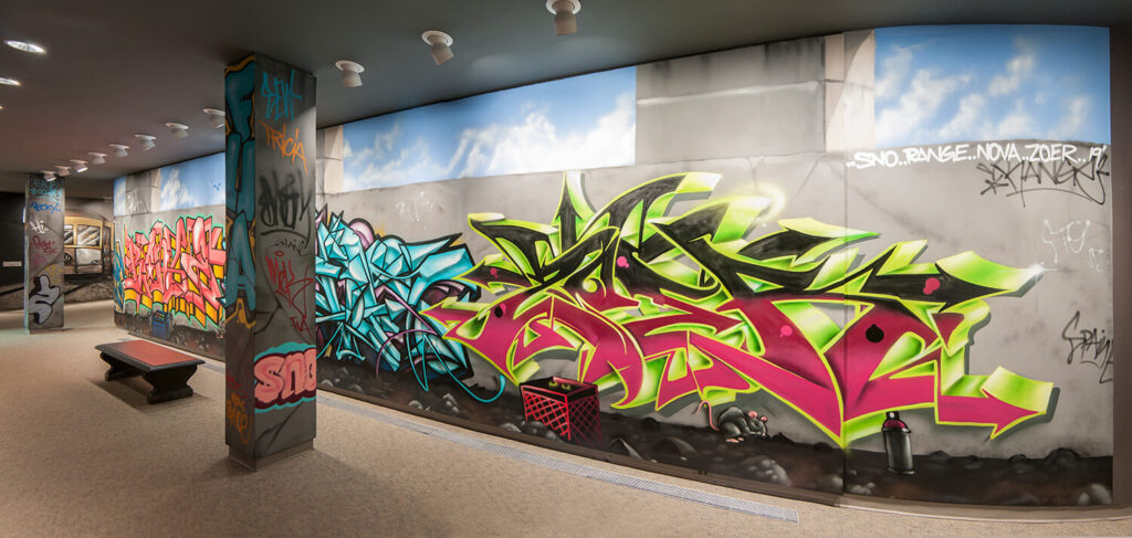 Graffiti designs and letters on the wall of MAG's Hurlbut Gallery.