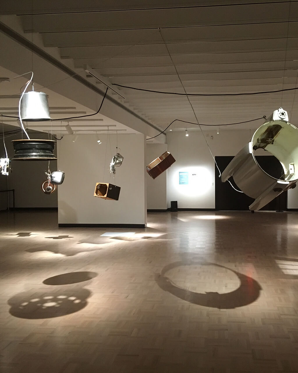 Many different kinds of objects suspended in place in a wide open room.