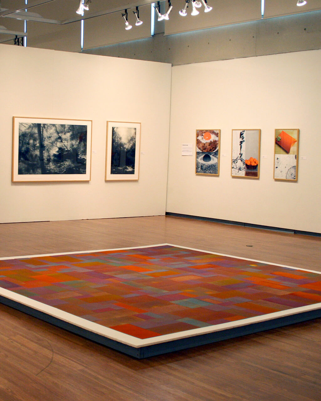 Works of art that relate to producing multiple copies of a single work of art, on the floor and white walls of a gallery.