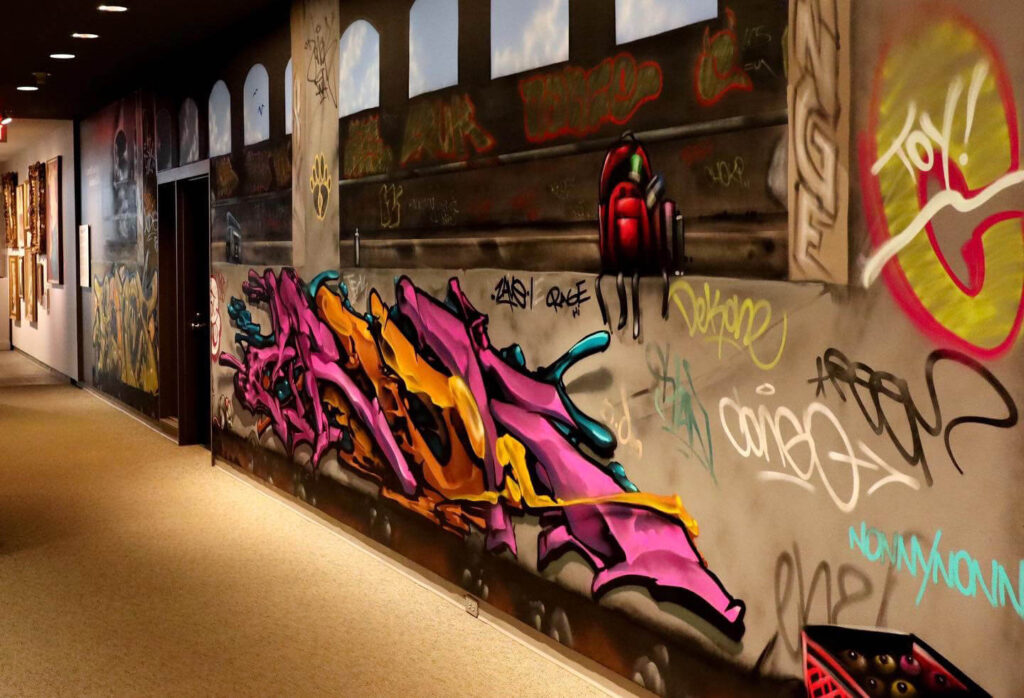 The wall of MAG's Hurlbut Gallery, spray-painted to look like a graffitied subway station.
