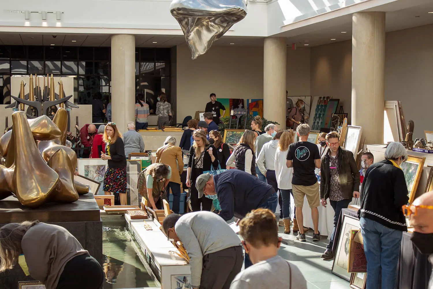 Shoppers looking through paintings in the Vanden Brul Pavilion at the 2022 Art & Treasures Sale.