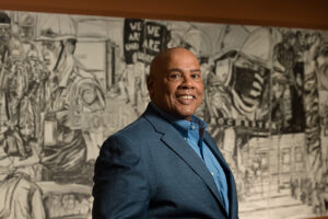 Michael Marsh stands in front of Shawn Dunwoody's work, Unfinished Business, in the Cameros Gallery.