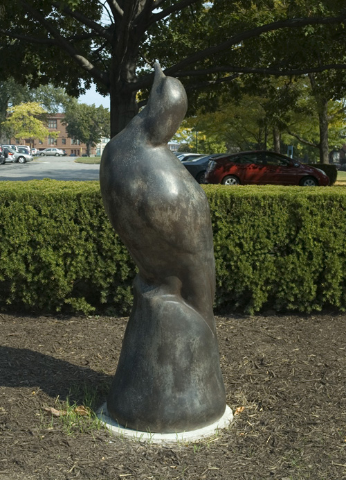 Bronze statue of a pigeon perched and looking up