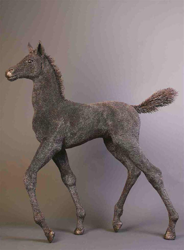 Metal statue of a young, prancing horse