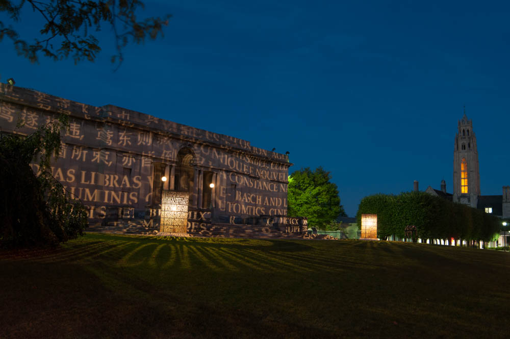 MAG building at night with words projected across the face of it from two pillars in front