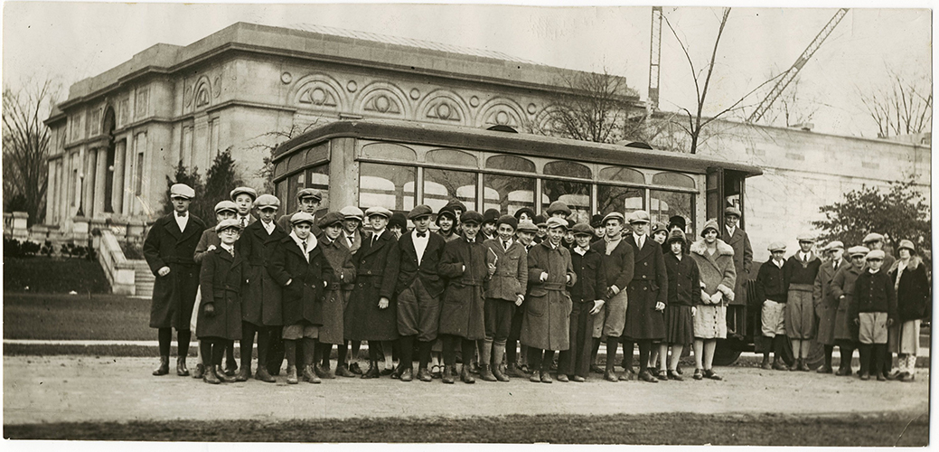 A sepia-toned photograph of young students outside MAG's 1913 building