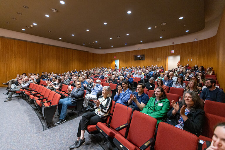 A full auditorium at a patrons' exhibition opening party