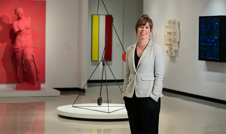 Jessica Marten standing in front of sculpture in the galleries