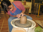 Shelly Green Stohler throwing a pot on a potter's wheel