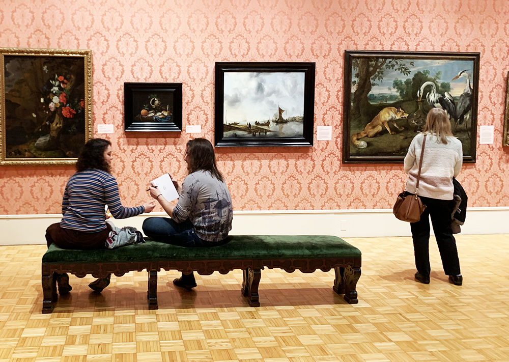 People sitting in the galleries, looking at artwork