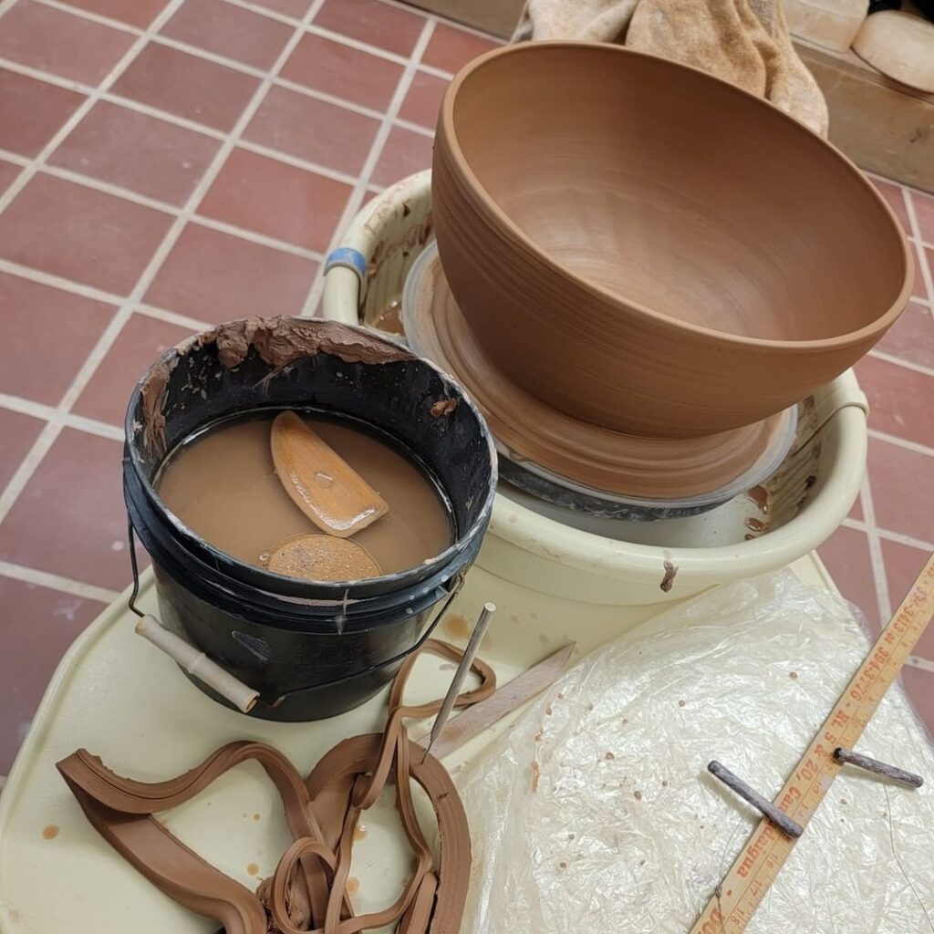 In progress clay pot being thrown on the potter's wheel