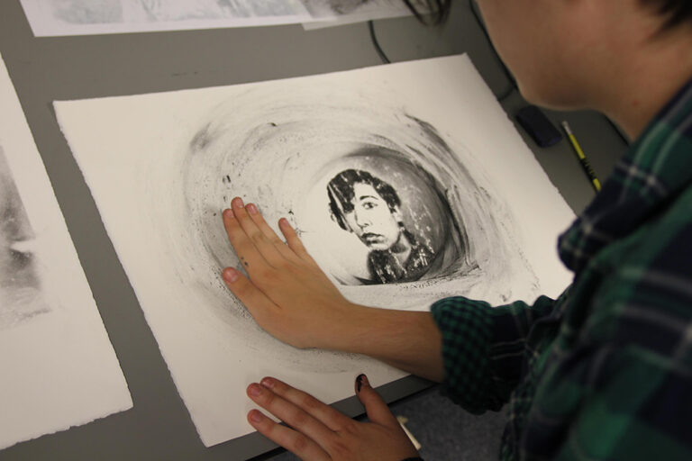 A view over someone's shoulder of a portrait on paper