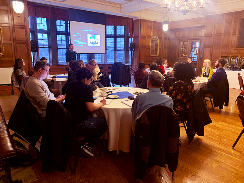 People sitting at tablets, paying attention to a presentation