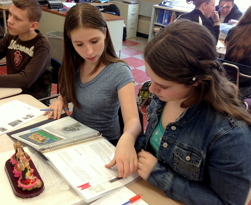 Two high school students looking at a workbook