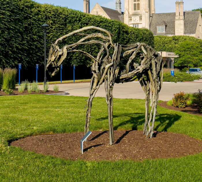 A bronze statue of a horse, the shape created with branches rather than a solid form.