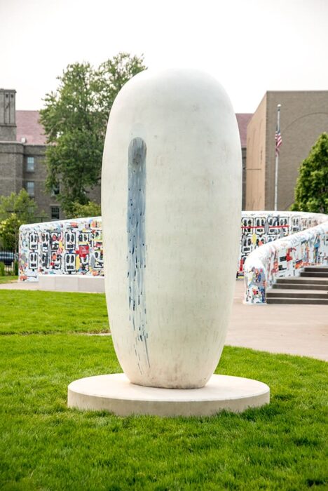 An oblong white sculpture with blue glaze trickling down the side.