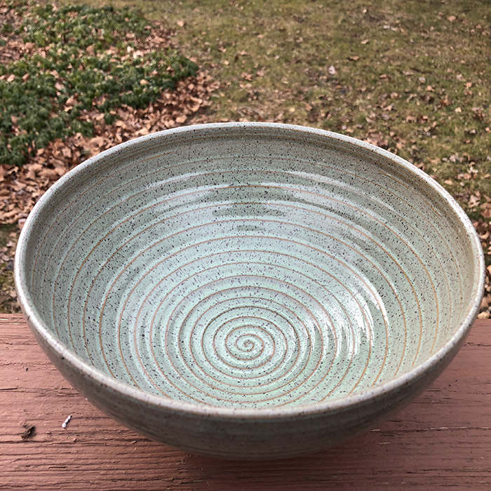 Ceramic bowl with a spiral pattern inside.