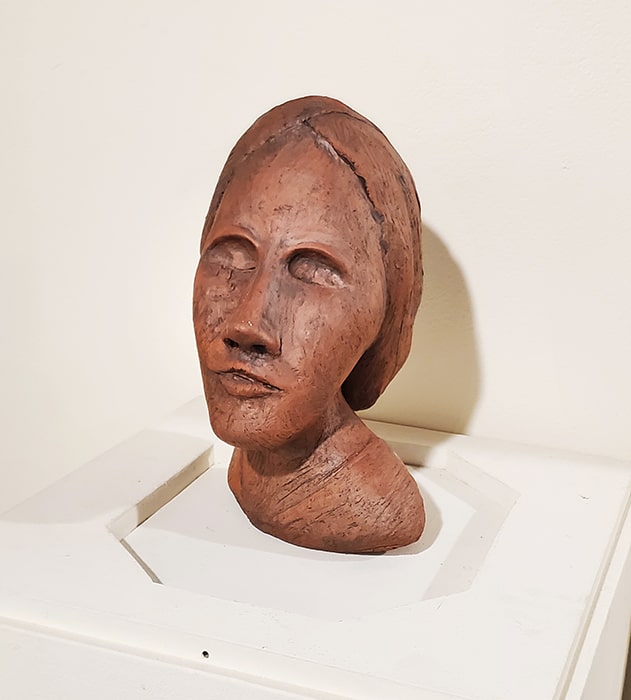 Terracotta sculpture of a woman's head.