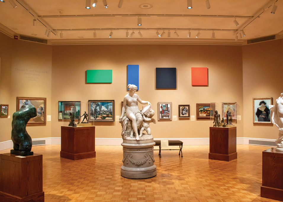 A gallery of 19th century European sculpture and painting, and Ellsworth Kelly's "Green Blue Black Red", consisting of four rectangular and square solid-color canvases, is hung on the wall above 19th century paintings.