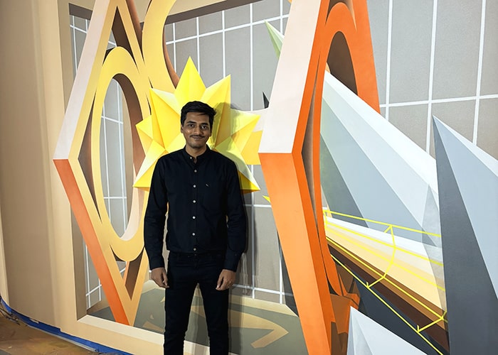 Avinash Kumar standing in front of his finished mural in the Hurlbut Gallery.