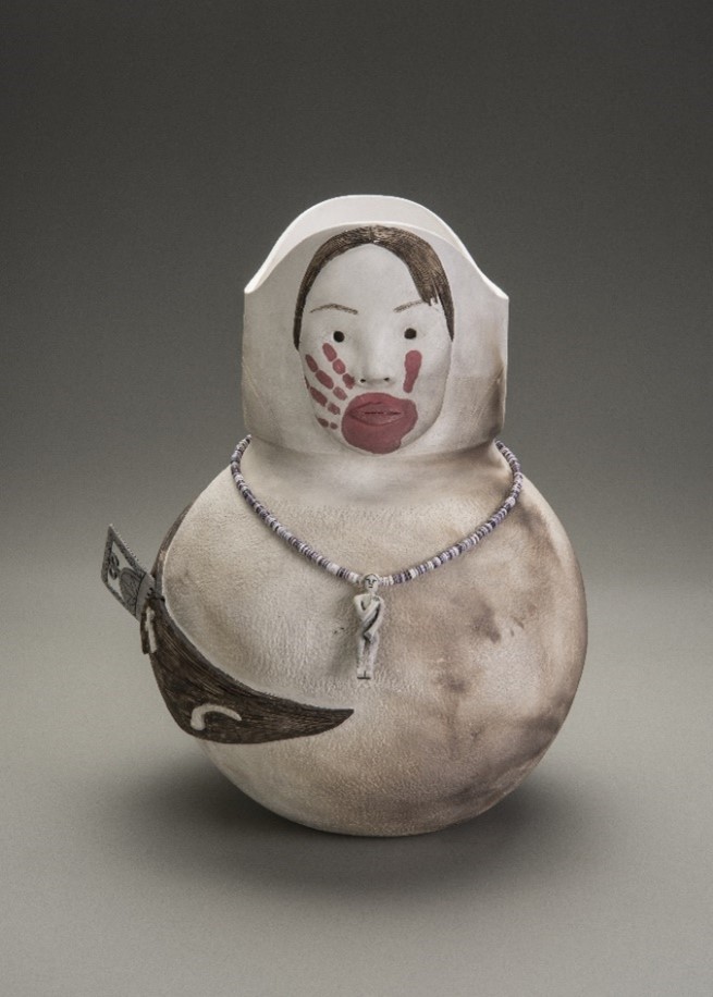 Rounded ceramic vessel with a woman's face and hair curling around the body. A red hand print covers the woman's mouth.