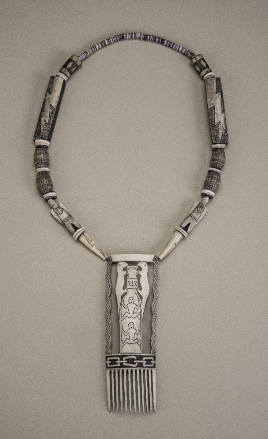 Necklace with a decorative comb pendant.