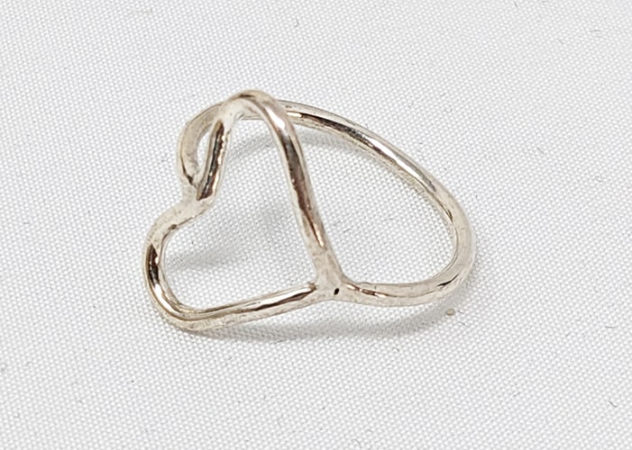 Silver ring with a heart shape made out of wire.