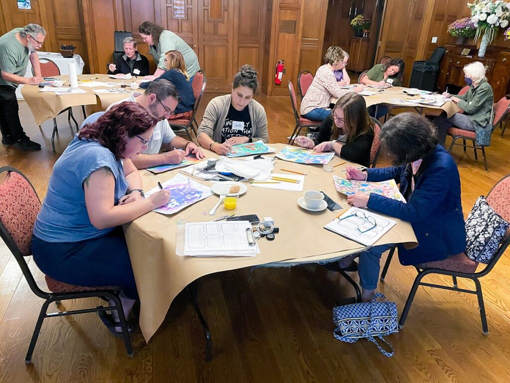 Teachers drawing and painting during a workshop.