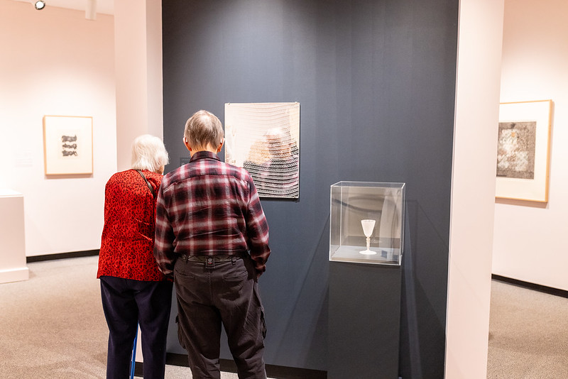 Two visitors in the exhibition Making Connections, looking at the works.
