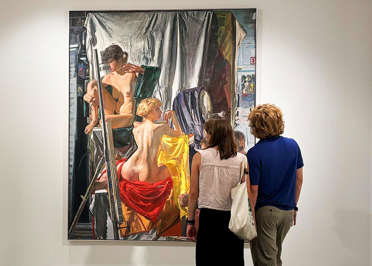 A couple of college students looking at a painting in the galleries.