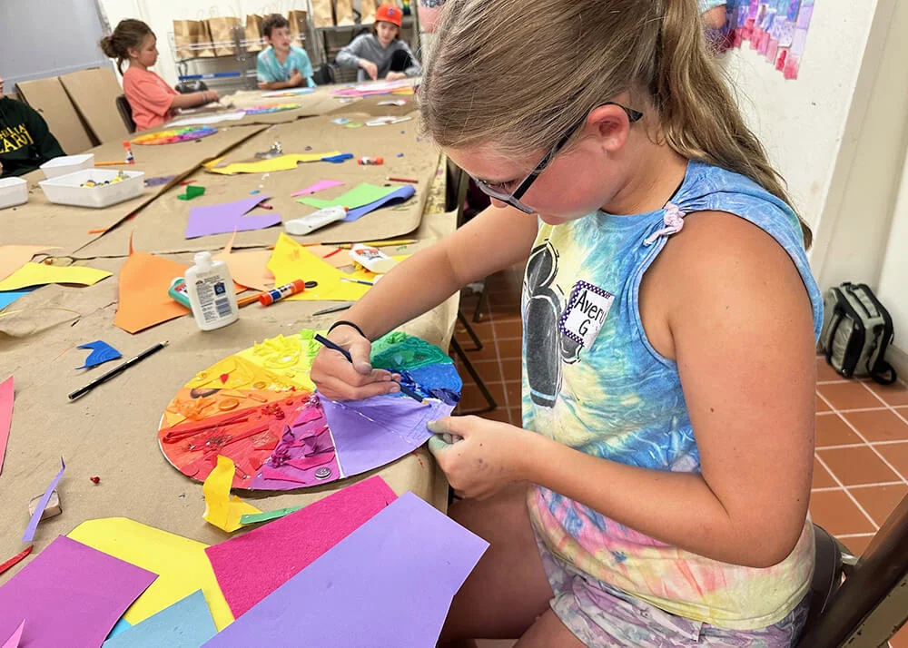 A girl painting a color wheel.