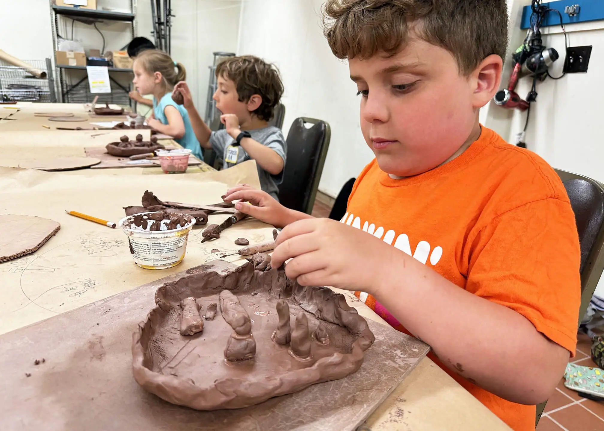 Kids creating organically-shaped ceramic bowls.