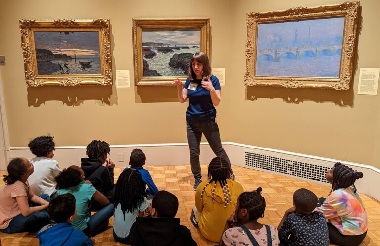 A guide talking to students in MAG's galleries as part of the ELC program.