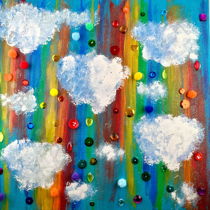 Painting of white clouds against a rainbow background, decorated with colorful buttons and sequins.