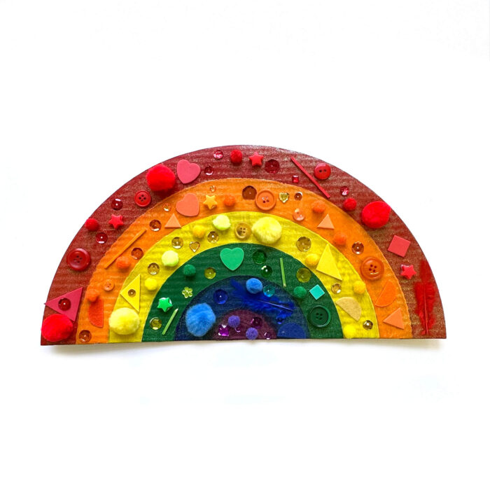 A rainbow with mixed media stuck to the different bands of color.